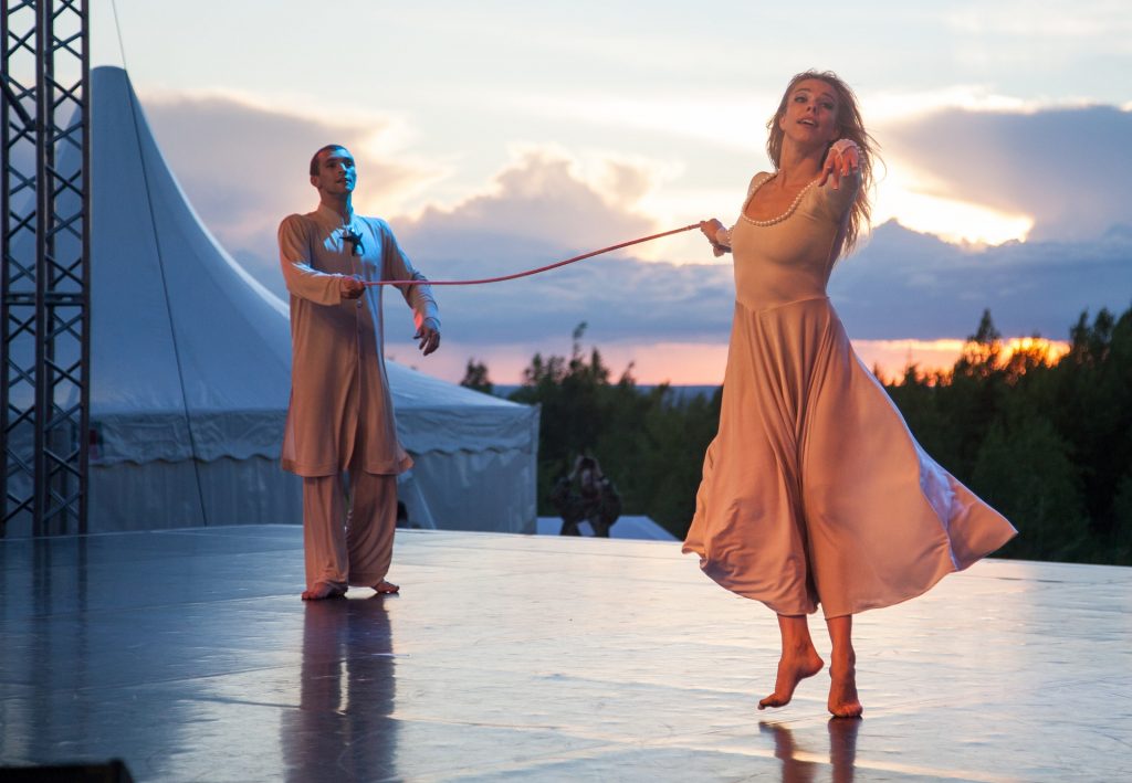 um casal de bailarinos distantes, mas ligados por um fio vermelho que os dois seguram